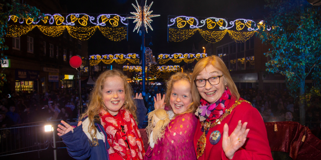 Light up Loughborough competition winners Katie and Emelia Corns switching on Loughborough's Christmas lights with the Mayor of Charnwood, Cllr Jennifer Tillotson.