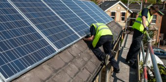 Solar panels being fitted to the roof of a house
